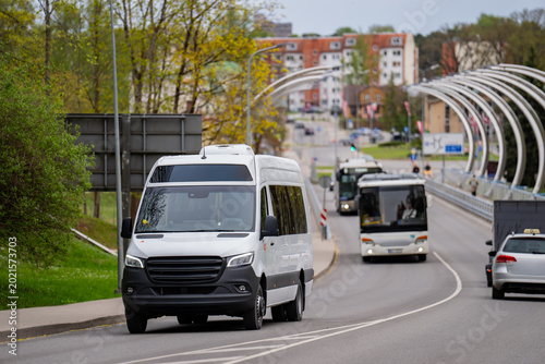 Tableau sur toile Delivery van and commuter buses navigating a paved highway in a European city en