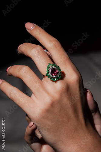 Tableau sur toile Hand wearing a pear-shaped ruby and an emerald ring
