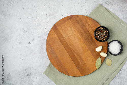 Kitchen tabletop with wooden board mockup, olive oil, garlic and wooden spoons. Top view, flat lay, copy space
