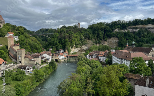 Picturesque view of the medieval old town and river Sarine in Fribourg Switzerland under dramatic clouds.