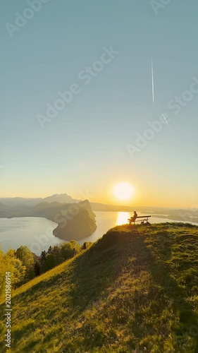 Person Sitting Alone on Bench Watching Sunset Over Lake Lucerne at Märibänkli Viewpoint Above Vitznau, Rigi, Switzerland (wide angle)