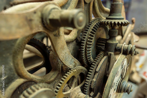 Quadro su tela A complex array of interlocking rusty gears and mechanical components from a historical clockwork system, highlighting vintage engineering