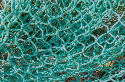 Close‑up of a tangled green fishing net showing detailed rope structure and maritime texture.