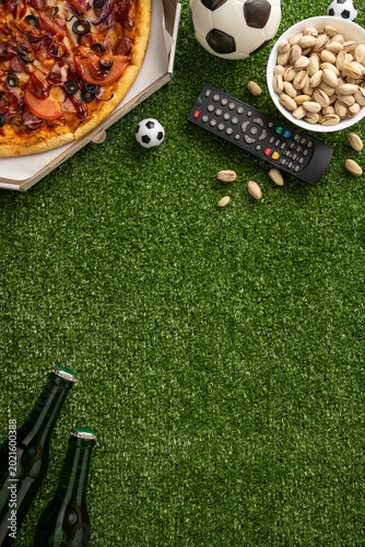 Fotografija Football championship watching setup with pizza, pistachios, beer and remote on