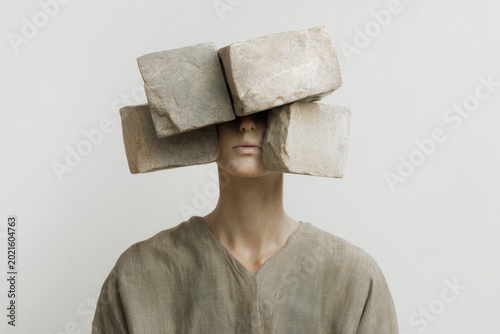 Minimal portrait of person with heavy stone bricks obscuring vision for burden and resilience conceptual poster background