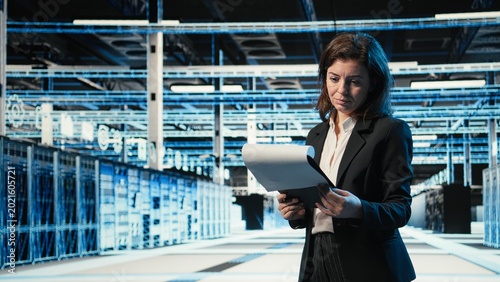 Quadro em tela Data center manager verifying infrastructure status with clipboard files and holographic visuals
