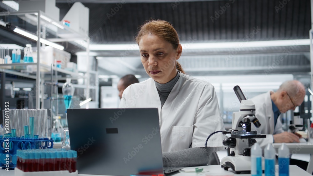 Naklejka premium Sick lab expert rubbing head temples, feeling ache while working on laptop, studying genomics. Fatigued laboratory technician hurting while studying DNA strand mapping on notebook, camera A