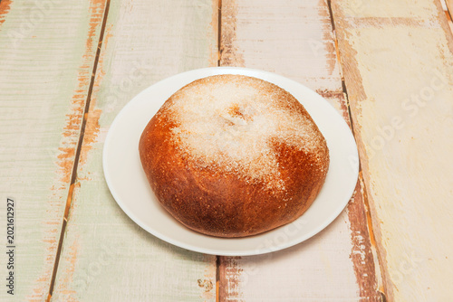 Bilde på lerret A golden pan de bono bread sits in a twisted black metal basket with white paper on whitewashed wooden planks