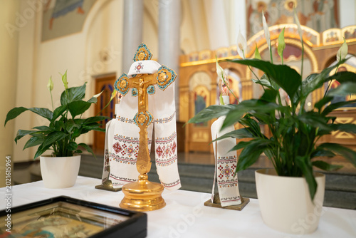 Foto Golden altar cross with embroidered rushnyk and peace lilies