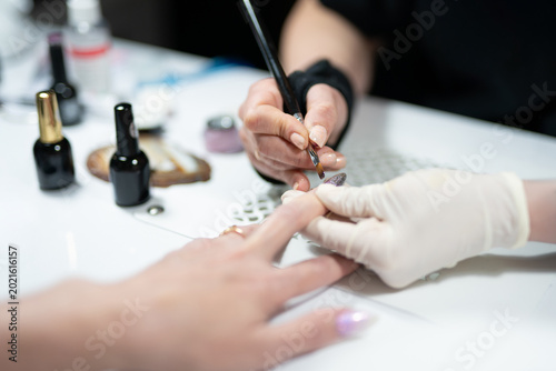 Konstfotografi Manicurist applying top coat to textured nail art