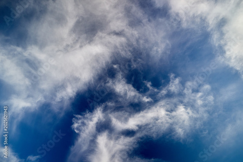 Foto Beautiful low angle shot of soft white altocumulus and cirrus clouds textures filling a vibrant blue sky on a windy summer day, natural backdrop