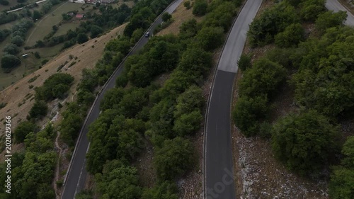 Winding road weaves through lush green hills under a cloudy sky at dusk in the tranquil countryside