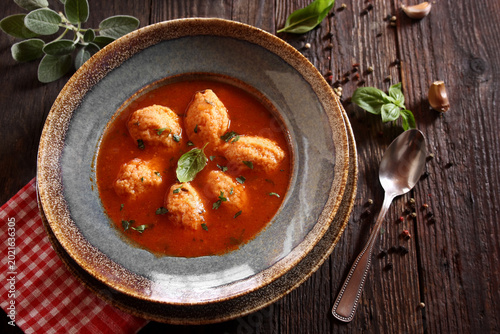 Bild auf Leinwand Tomato soup with semolina dumplings on a wooden background