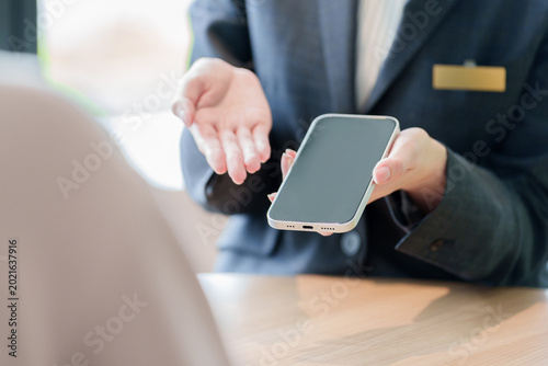 スマートフォンの説明をする販売員の女性