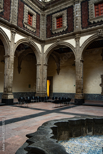 Colonial courtyard with stone arches and historic fountain in Mexico