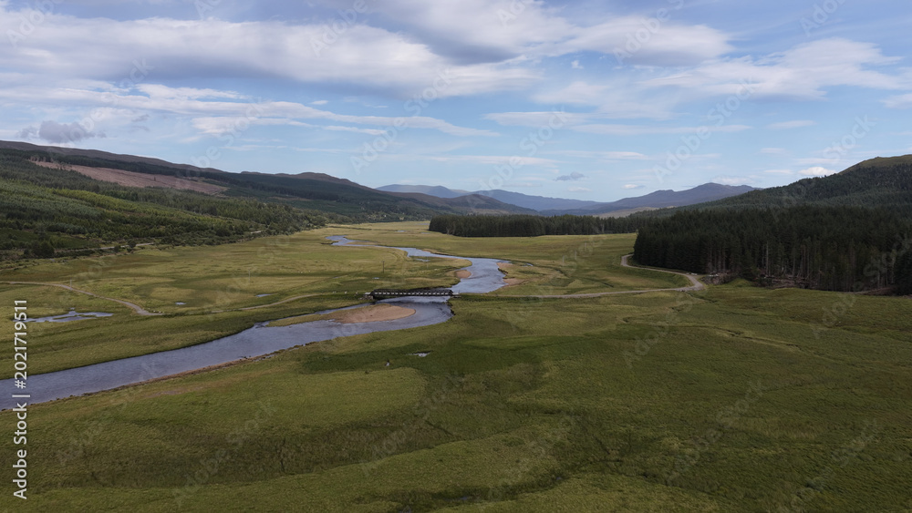 Fototapeta premium Aerial View of a Winding River and Bridge in Scottish Highlands