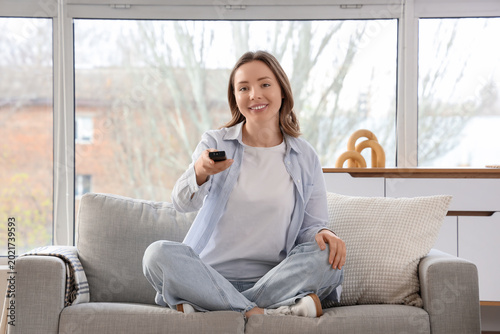 Young woman sitting on sofa...