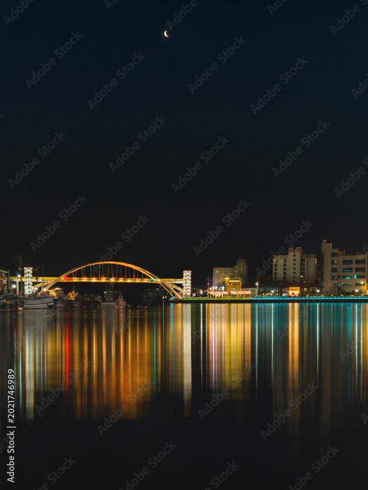 Fototapeta premium Seascape at the illuminated Gangguan Port and Bridge at dark sky night in Tongyeong‑si, Gyeongsangnam‑do, South Korea