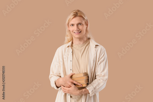 Young blonde man with books...