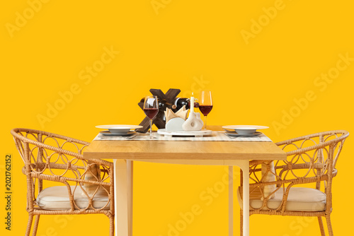 Served restaurant table with wine on yellow background