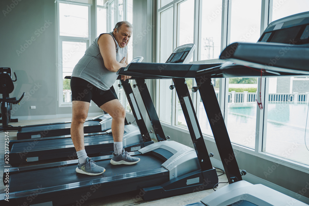 Fototapeta premium Senior Man Suffering Chest Pain from Possible Heart Condition in Gym