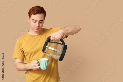 Young man pouring hot water...