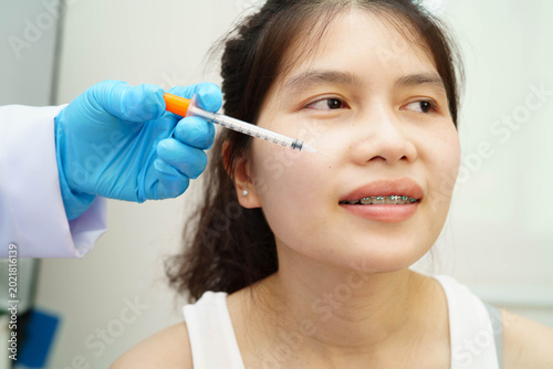 Foto Asian woman receiving lip contouring procedure augmentation performed on face