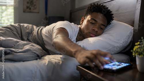 Tired man waking up checking smartphone