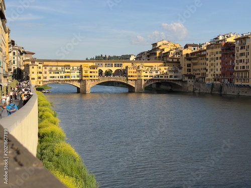 Cuadro en lienzo Arno river flowing past the historic ponte vecchio bridge in florence, italy, wi