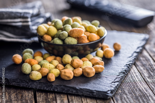 Close-Up Bowl of Coated Peanuts and Crunchy Snack Mix in a Rustic Dark Setting