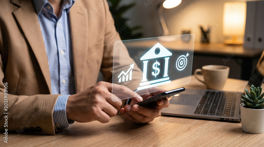 Naklejka premium Businessman using smartphone with digital financial icons hologram in modern office environment