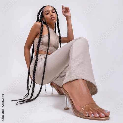Elegant fashion portrait with stylish woman in neutral outfit and clear heels Modern female fashion
