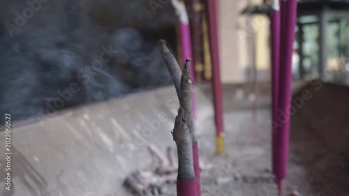 Smoking incense sticks in a traditional censer with blurred background