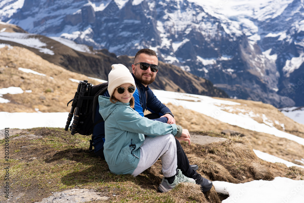 Fototapeta premium men with daughter hiking in the Swiss Alps mountains during vacation, Grindelwald, First Cliff Walk
