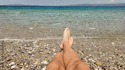 Man sunbathing on a rocky sea ocean beach.