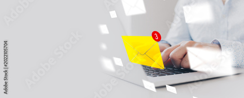 Fotografie Sending messages while checking email notifications on a laptop