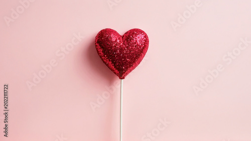 Floating red heart candy balloon with glitter on minimal pink advertising background