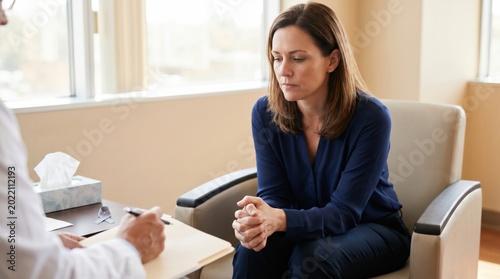 Woman in deep thought during a therapy session with a doctor.