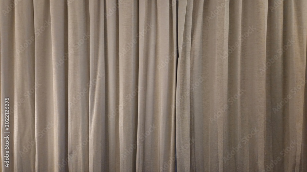 Obraz premium Beige fabric curtain texture with vertical folds and drapes