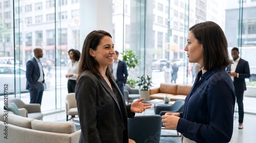 Professional Female Colleagues Discussing Business Strategy in Office Lounge