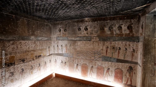 Close-up of ancient Egyptian relief carving inside KV17 tomb of Seti I, Valley of the Kings, Luxor, Egypt, showing a deity figure with black hair and deteriorating pigment.