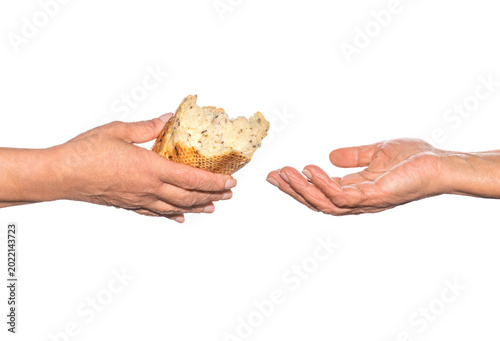 Pieces of bread. Helping the homeless. Elder woman hand give a loaf of bread to hands of a beggar. Poverty and world hunger concept