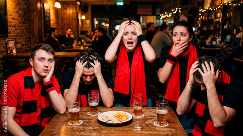 Group of sports fans shows astonishment and frustration together