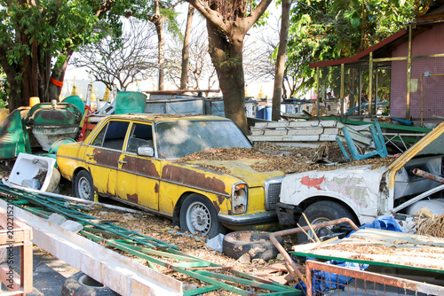 Obraz na płótnie Old rusty wreck car and the waste of construction materials equipment