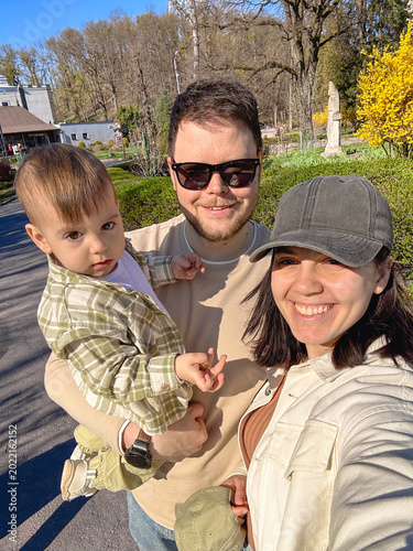 Happy young family selfie in sunny spring park Selfie