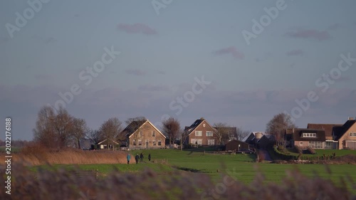People Walking on Scenic Path in De Donk Village at Sunset