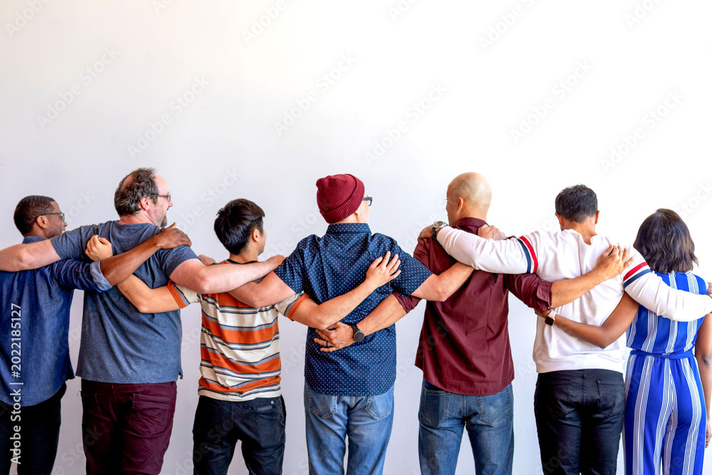 Fototapeta premium Diverse group of people standing with arms around each other.