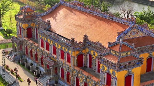 Kien Trung Palace in Hue Imperial City with a vibrant yellow facade, red shutters and roof details. Aerial Drone Shot