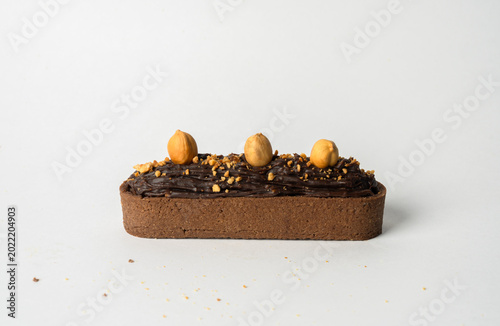 Photography A decadent tarte topped with rich chocolate and crunchy hazelnuts, featuring a buttery, flaky crust and smooth, indulgent filling, perfect for dessert lovers
