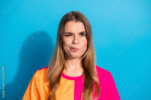 Photography Bright young woman in a vibrant color blocking top smiles confidently blue backg